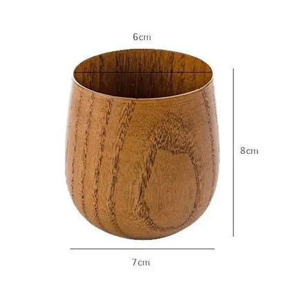 Hand holding a Japanese wooden tea cup for size