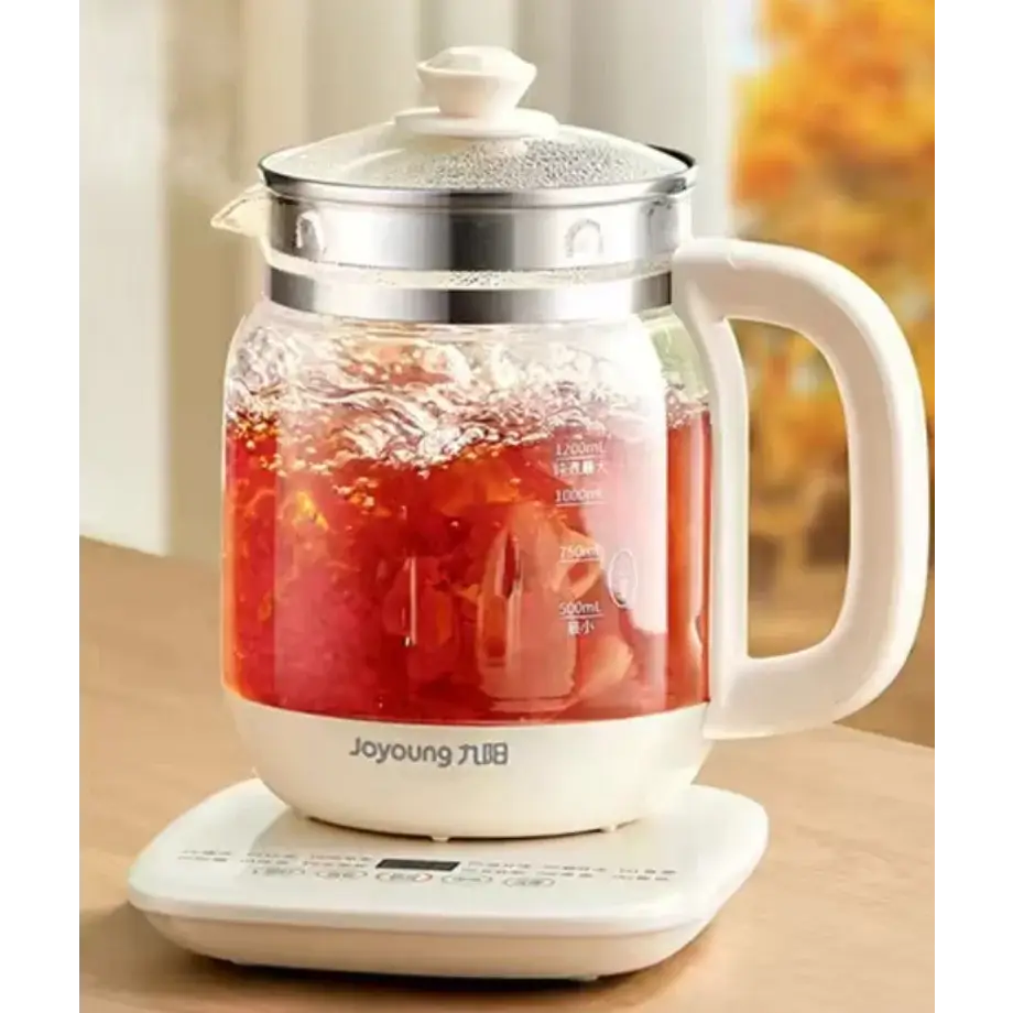 Electric teapot pouring hot water into cup