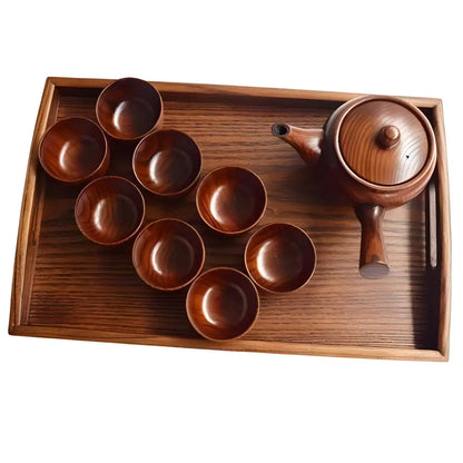 Hands using wood kyusu teapot to pour tea into small cup
