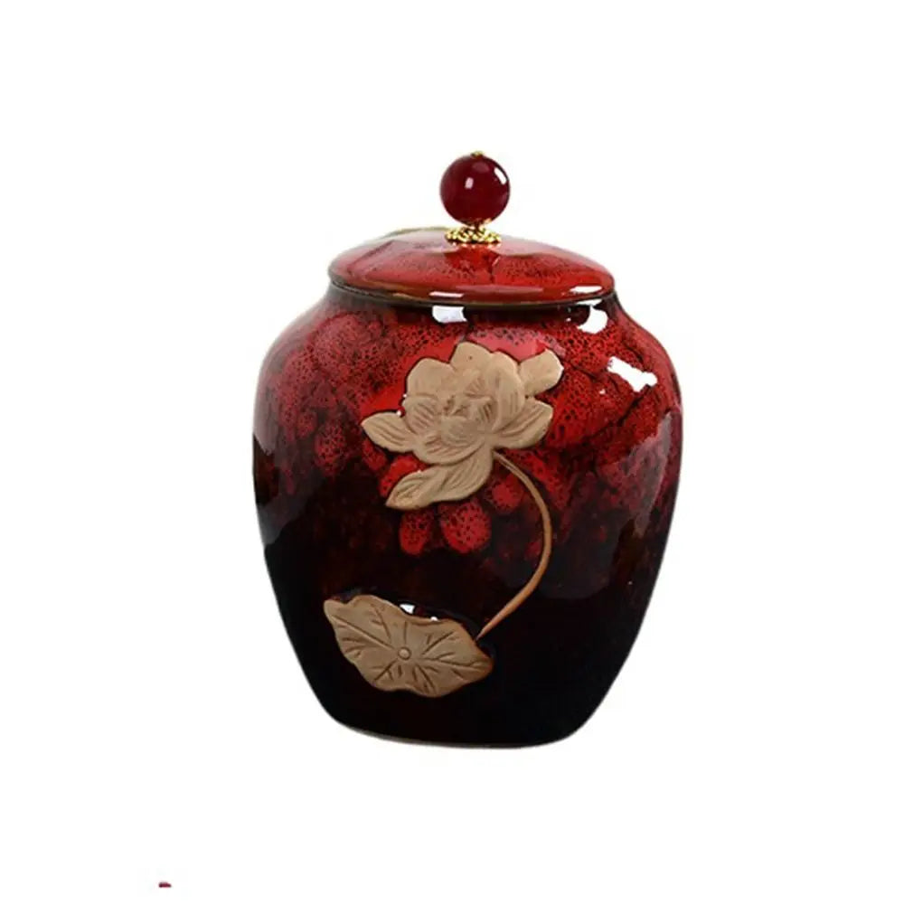 Red ceramic tea jar with lid, on wooden table