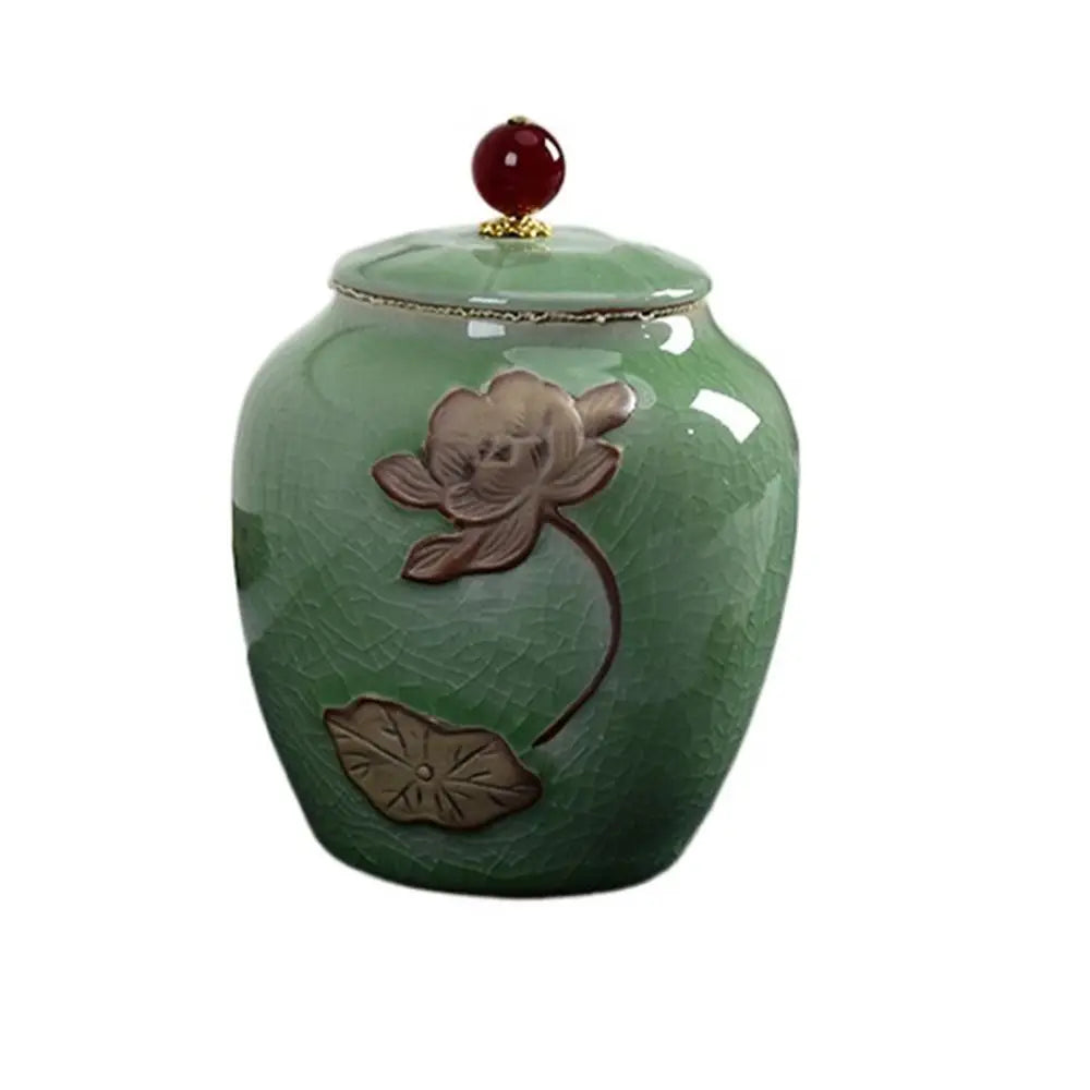 Green ceramic tea canister with lid, full front view showing glaze finish