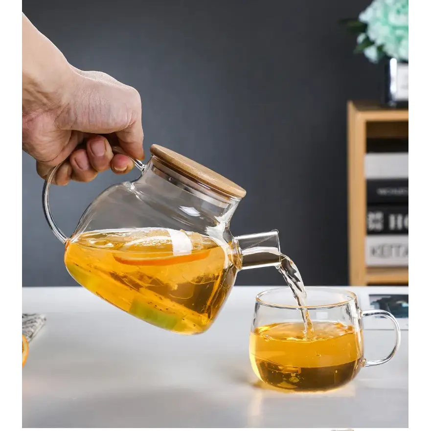 1-liter glass teapot pouring brewed loose leaf tea into a cup
