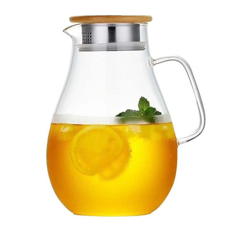 Large glass teapot with bamboo lid on wooden table, Scandinavian design