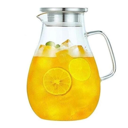 Glass teapot with infuser pouring loose leaf tea into ceramic cup