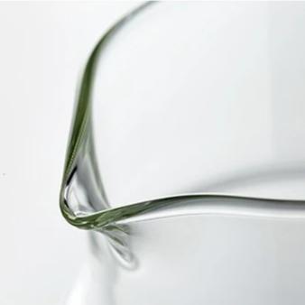 Glass teapot with bamboo lid and two cups of tea, top view