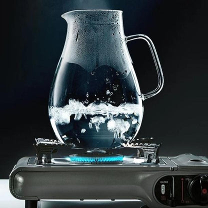 Large glass teapot with steel lid on kitchen counter, side view