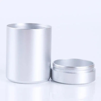 Large tea storage tin canister styled on a kitchen counter beside a cast iron teapot