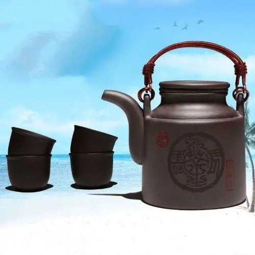 Red Yixing clay teapot and four cup gift set arranged on table