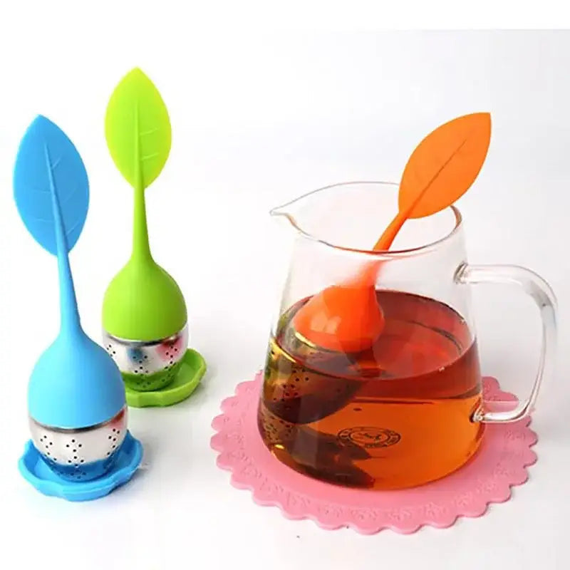 Leaf tea infuser with green silicone handle on a saucer
