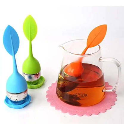 Leaf tea infuser with green silicone handle on a saucer