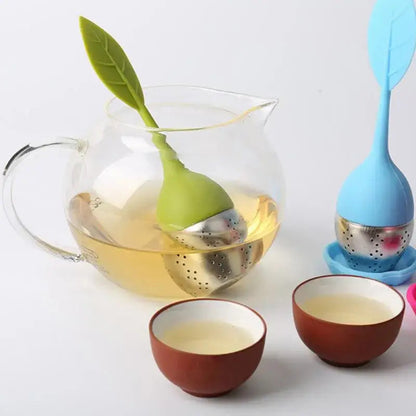 Person holding leaf tea infuser over a cup of tea