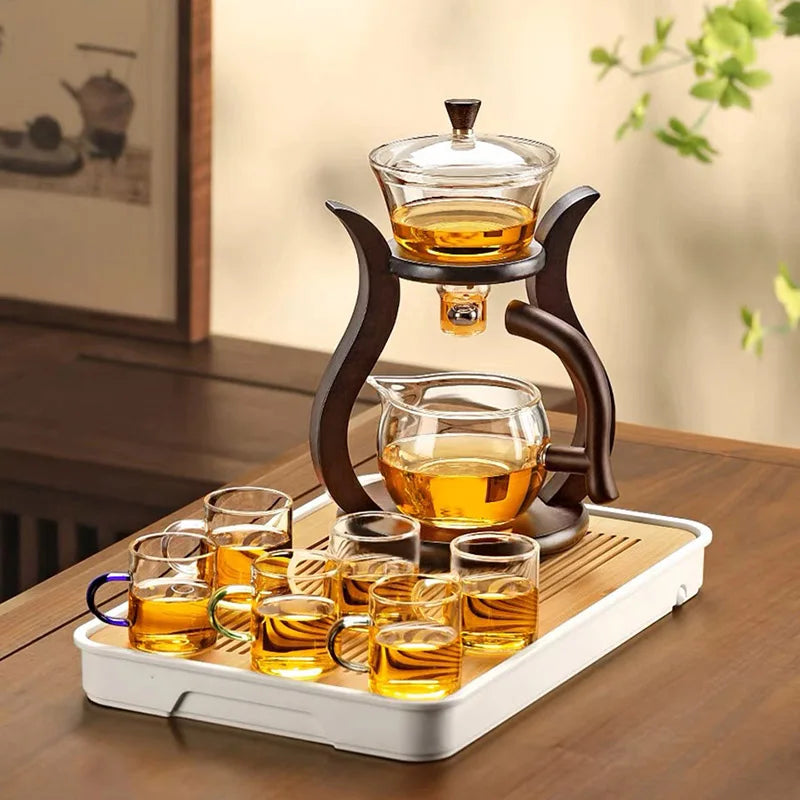 Pouring loose-leaf tea from magnetic rotating glass teapot into a cup