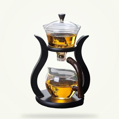 Magnetic rotating glass teapot with infuser on plain background