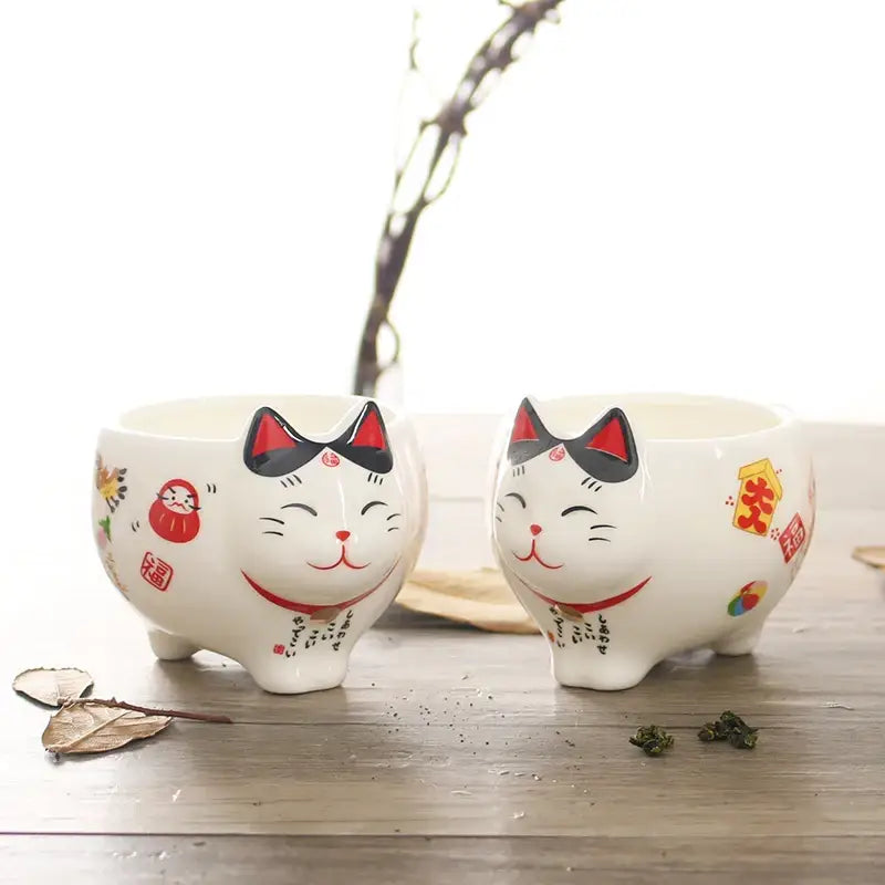Close-up of lucky cat teapot spout and curved handle detail