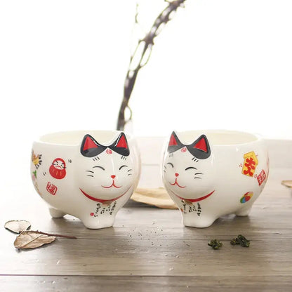Close-up of lucky cat teapot spout and curved handle detail