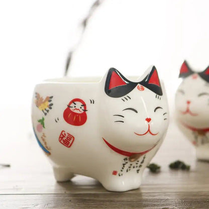 Pouring tea from lucky cat Japanese porcelain teapot into cup