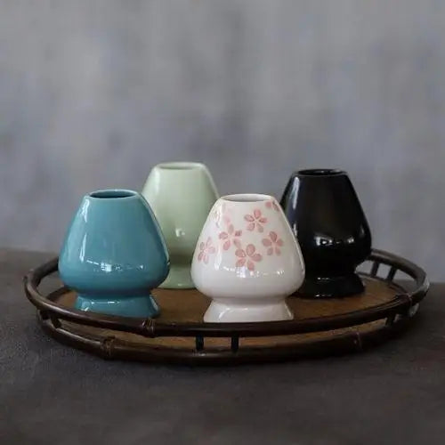 Chasen resting on porcelain matcha whisk holder, tines facing up