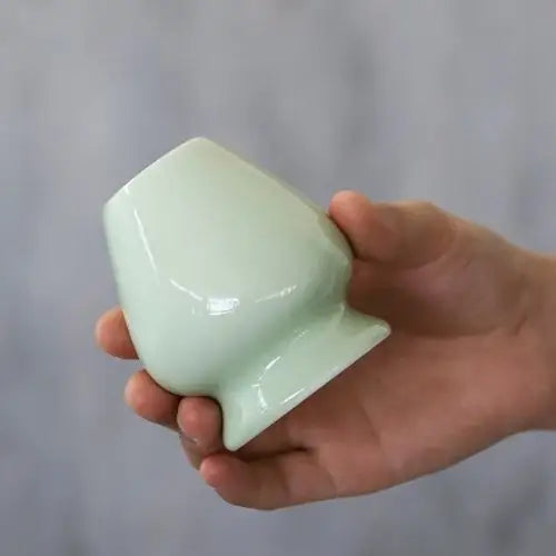 Green porcelain chasen stand with matcha whisk, side view