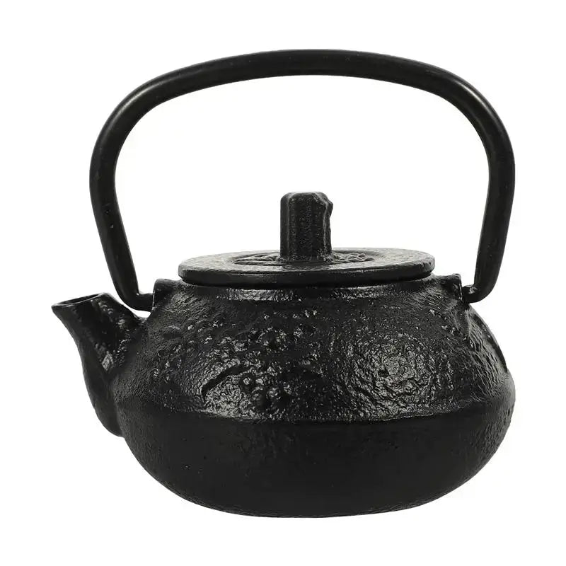 Small cast iron teapot on wooden desk