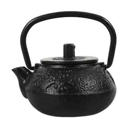 Small cast iron teapot on wooden desk