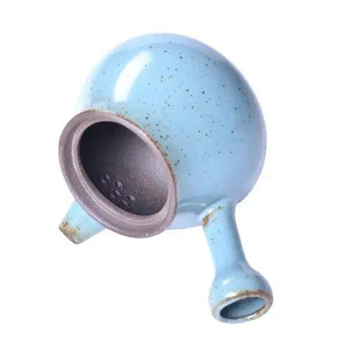 Side view of mini ceramic teapot showing handle and spout