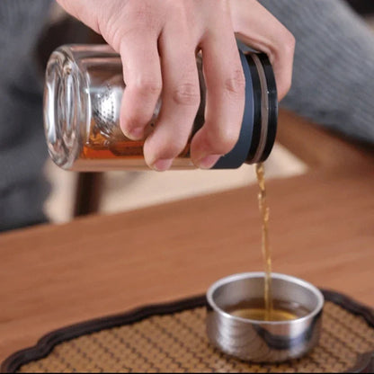 Double wall glass tea infuser filled with loose leaf green tea before steeping