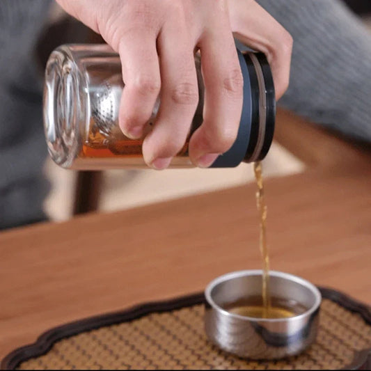 Double wall glass tea infuser filled with loose leaf green tea before steeping