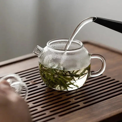 Heat resistant glass teapot with tea leaves