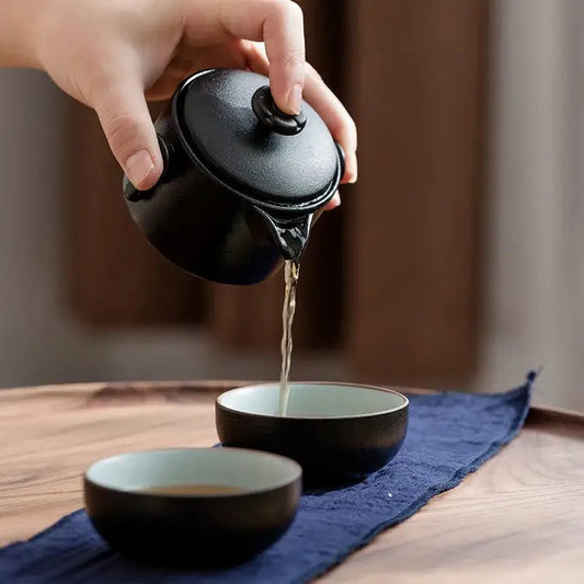 Compact travel tea set showing 175ml teapot beside two 60ml ceramic cups