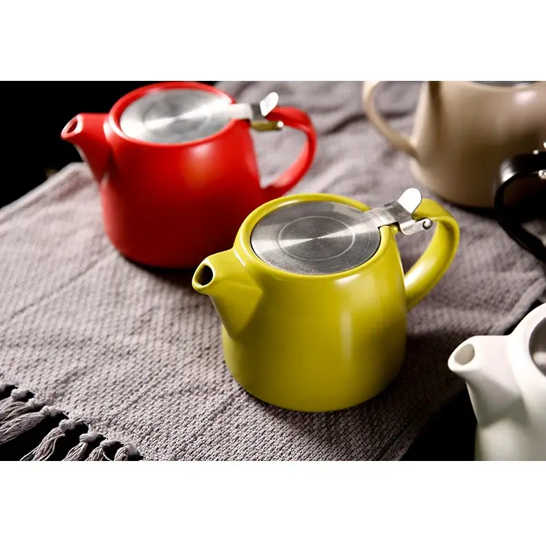 Modern ceramic teapot pouring tea into cup