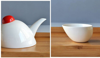 Porcelain teapot with cups on a kitchen counter