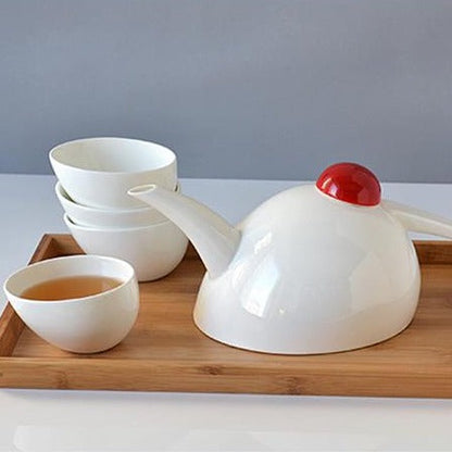 Scandinavian porcelain teapot set with four cups viewed from above