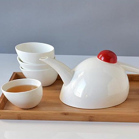 Scandinavian porcelain teapot set with four cups viewed from above