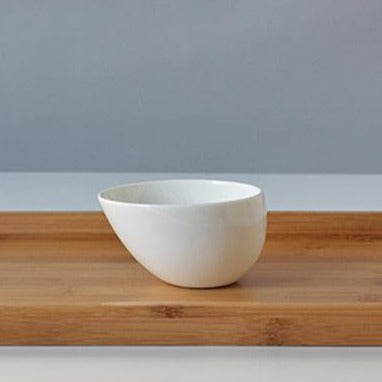 White porcelain teapot and cups in soft natural window light