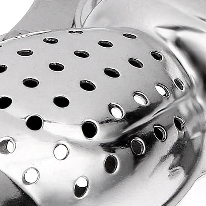 Monkey tea infuser hanging on the edge of a white mug