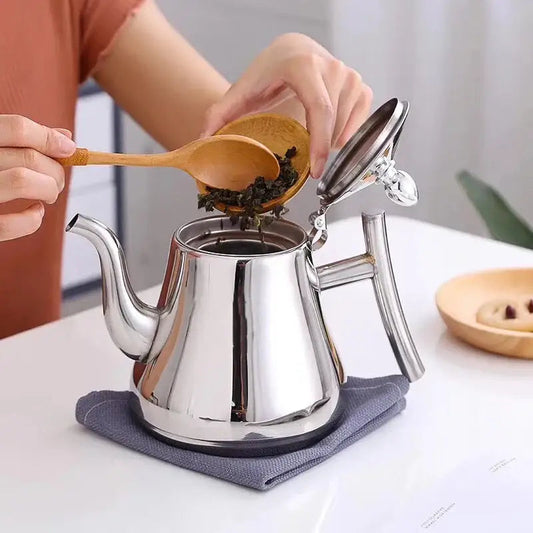 Moroccan stainless steel teapot pouring mint tea into traditional glass cup