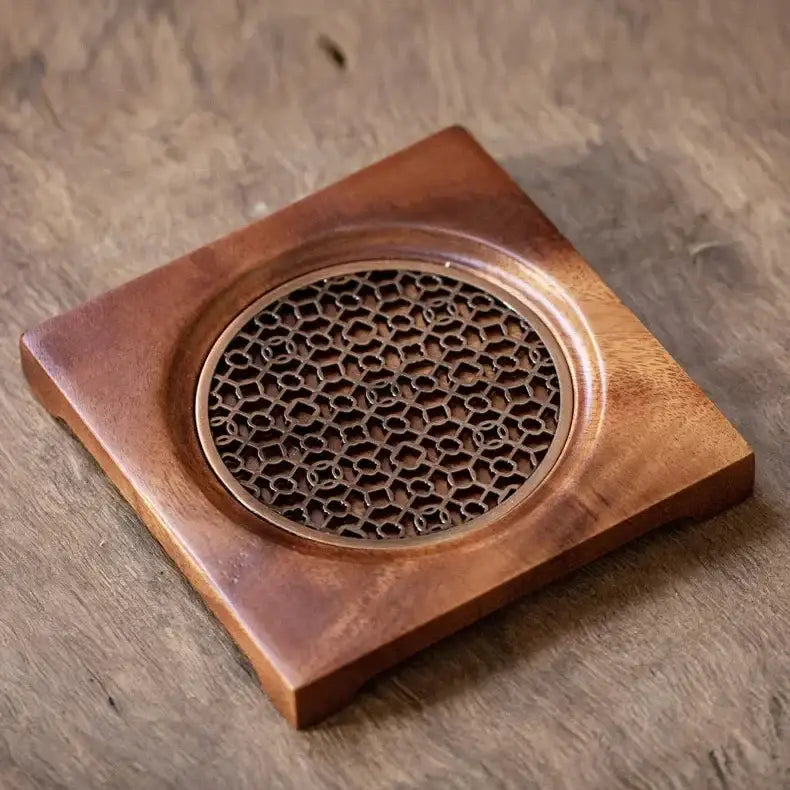Natural wood teapot stand with grid pattern on kitchen countertop