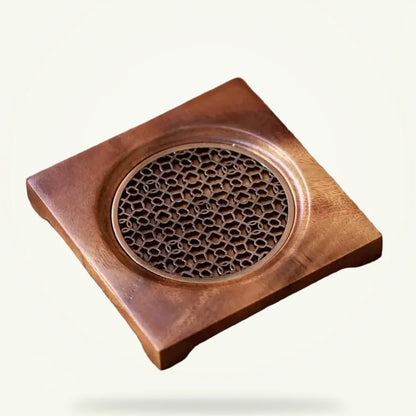 Natural wood teapot trivet with decorative grid pattern, packshot on plain background