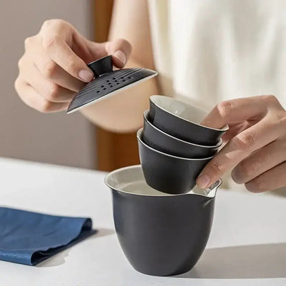 Travel porcelain teapot set in use, tea being poured into cup