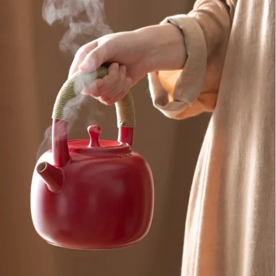 Red ceramic teapot 750ml with steam rising from the spout
