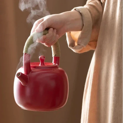 Red ceramic teapot 750ml with steam rising from the spout