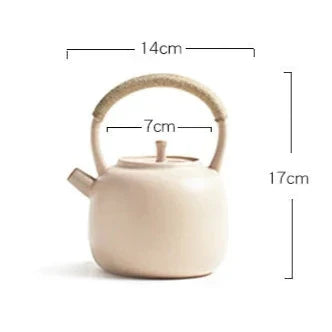 Scandinavian teapot beside loose-leaf green tea on a tray