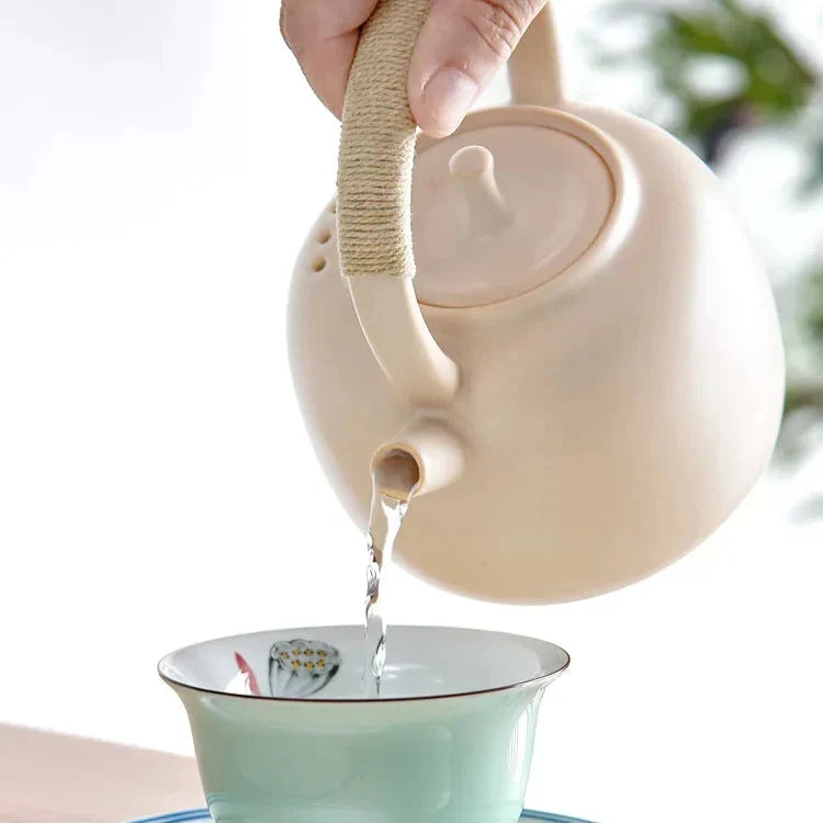 Black Nordic teapot with a brewed cup of tea, overhead angle