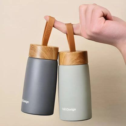 Nordic insulated tea bottles all four colors on a wooden surface