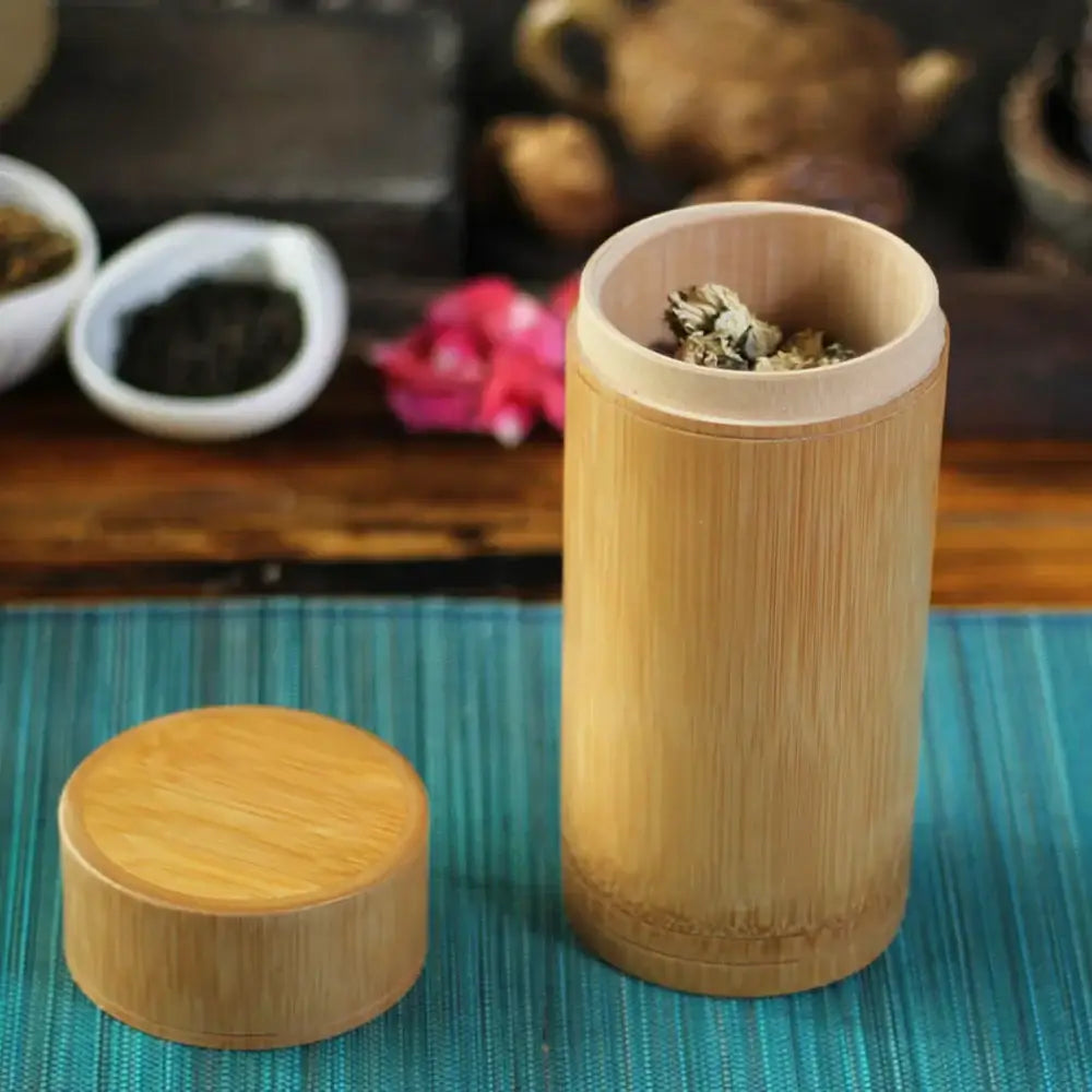 Bamboo tea canister on kitchen counter next to cast iron teapot