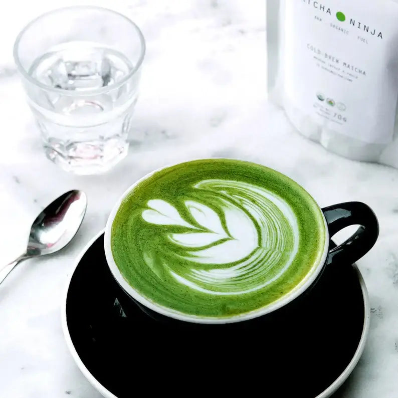 Whisking matcha green tea powder in a ceramic bowl