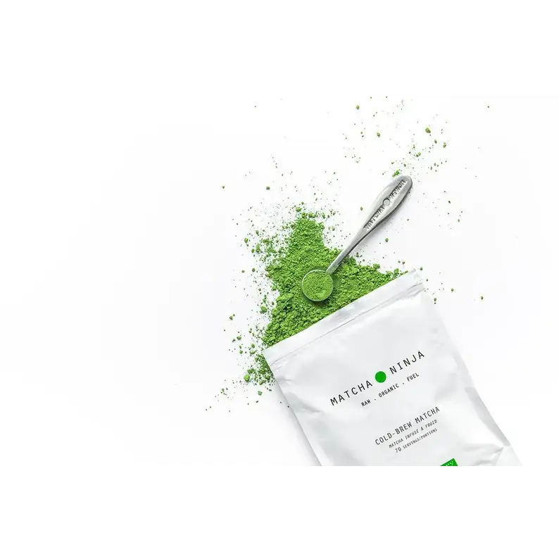 Matcha green tea powder with a bamboo scoop