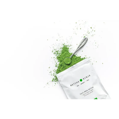 Matcha green tea powder with a bamboo scoop