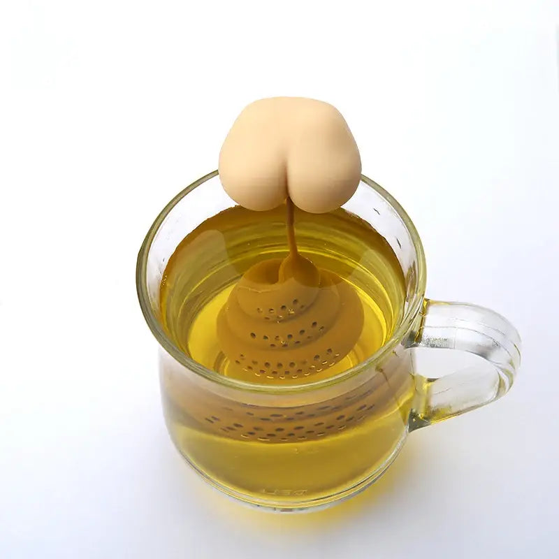 Silicone poop tea strainer sitting inside a white porcelain mug