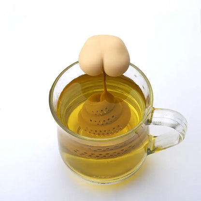 Silicone poop tea strainer sitting inside a white porcelain mug